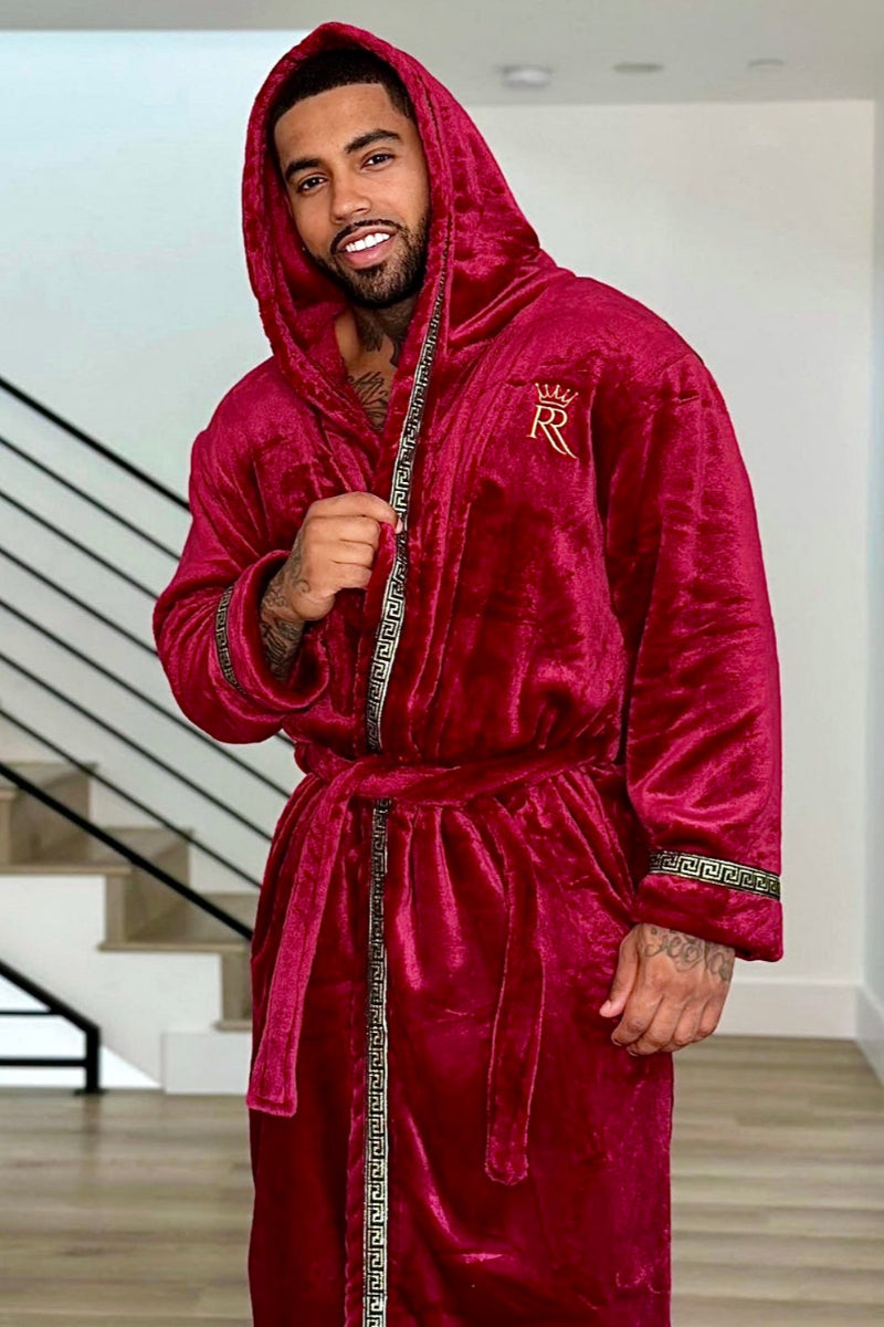 Man wearing the burgundy hooded Royalty Robe with gold Greek key trim and pockets. Soft fleece bathrobe with hood.