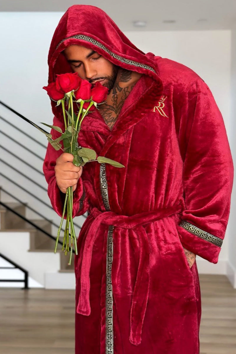 Man wearing the burgundy hooded Royalty Robe with gold Greek key trim and pockets. Soft fleece bathrobe with hood.