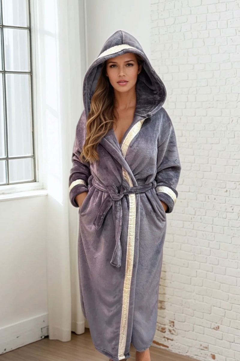 A model wearing a grey hooded Royalty Robe with gold and silver Greek key trim. Soft fleece bathrobe for women with hood and pockets.