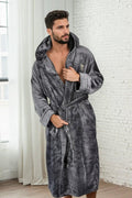 Male model wearing a soft fleece, grey bathrobe with hood. 