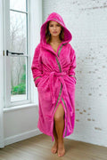 Pink Hooded Royalty Robe - Royalty Robes - model wearing a bright pink fuchsia bathrobe with gold Greek key trim and pockets.