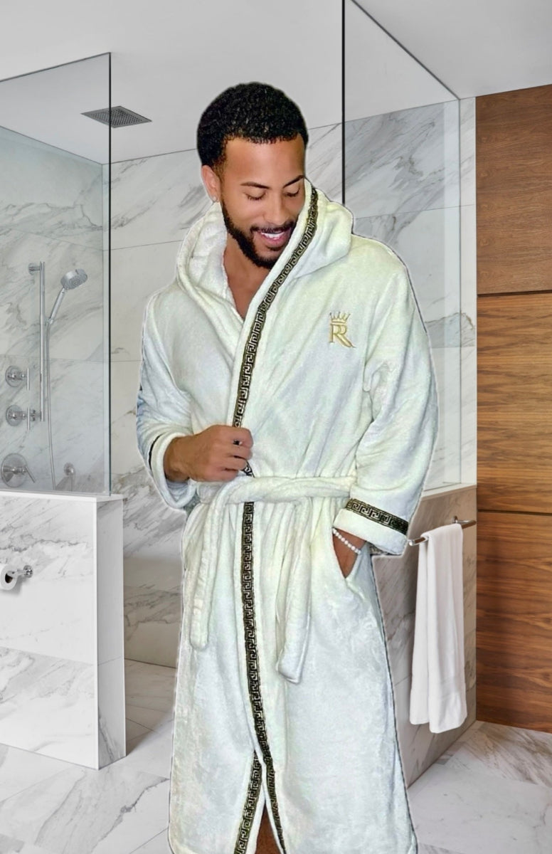 Man wearing the white hooded Royalty Robe with gold Greek key trim and pockets. Soft fleece bathrobe with hood for men.