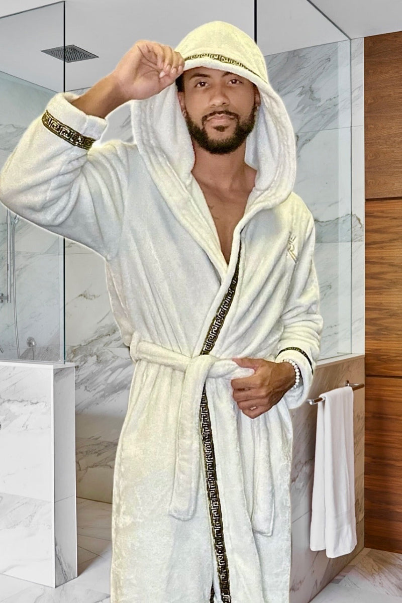 Man wearing the white hooded Royalty Robe with gold Greek key trim and pockets. Soft fleece bathrobe with hood for men.